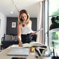 Mature woman working indoors in home office in container house in backyard